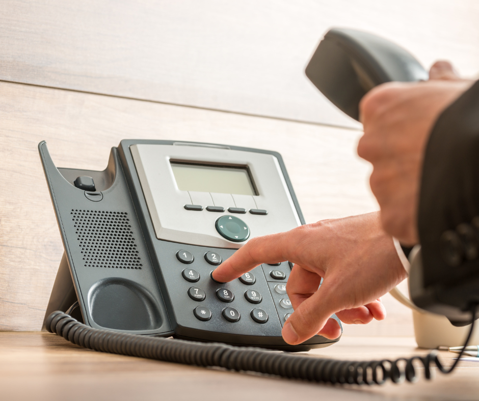 someone pressing numbers on a desk phone
