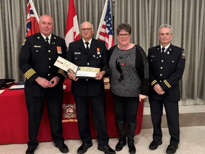 Chief Brian Moore with Tim Yandeau, who was acknowledged for 25 years of service to the department, his partner Linda and Scott Hayes.