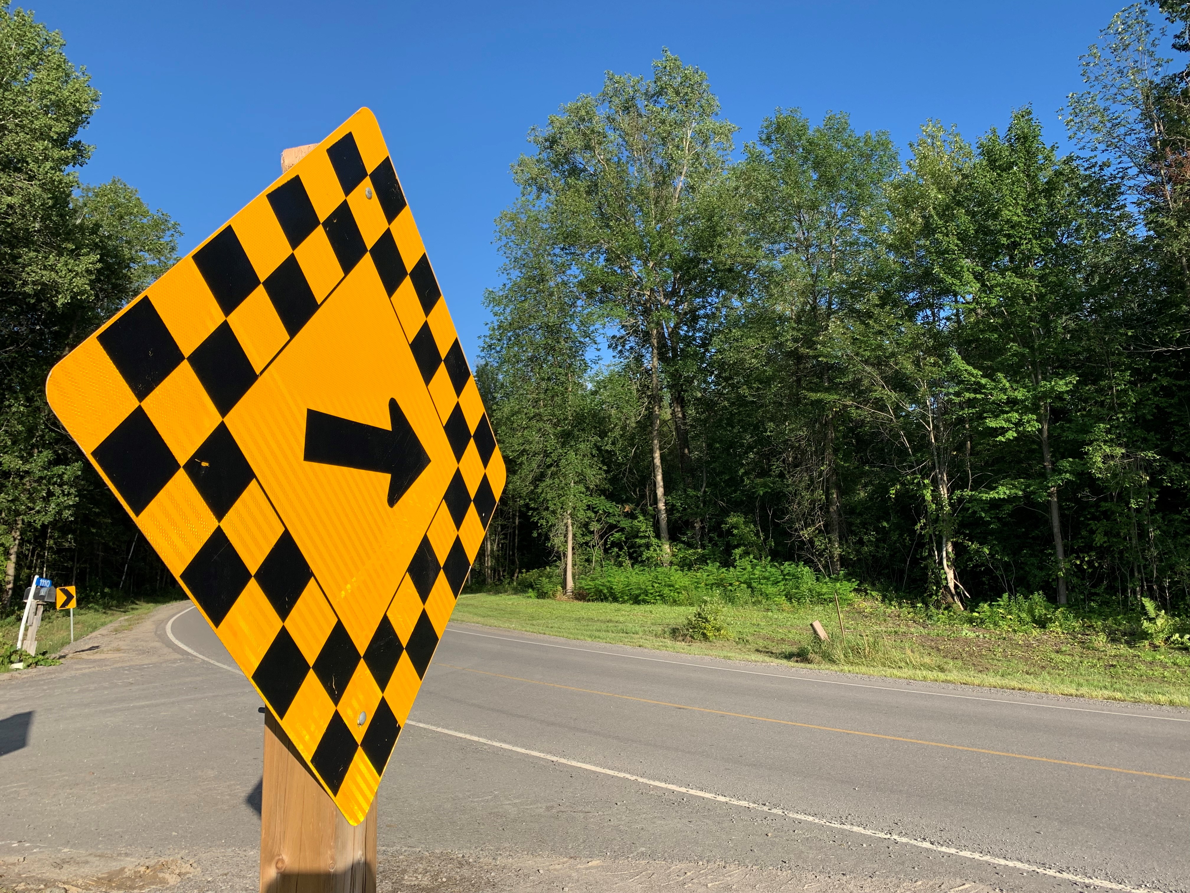 a curved road with caution sign
