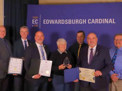 Group standing with certificates and an award in front of TWPEC backdrop.