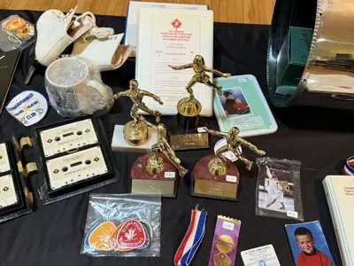 Table with skates, medals, test sheets, trophies and photos from the club