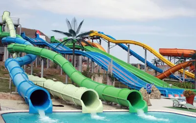 multiple colourful water slides empty into a shallow outdoor pool