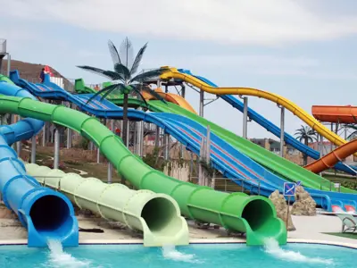 multiple colourful water slides empty into a shallow outdoor pool