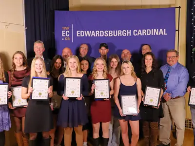 Group of youth and adults holding certificates in front of TWPEC backdrop.