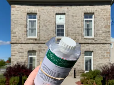 water sample bottle with township hall in the background
