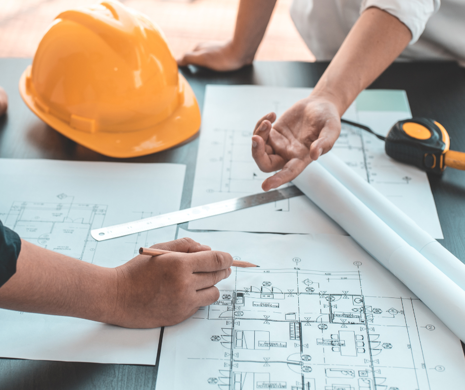 Two people reviewing a building floor plan