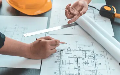 Two people reviewing a building floor plan