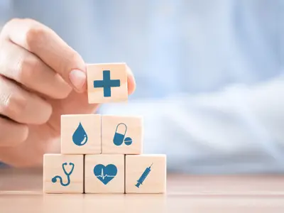 toy building blocks with medical icons being arranged in a pyramid