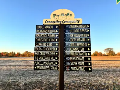 roadside sign with multiple business names and directions
