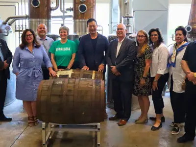 Dignitaries posed inside distillery workshop