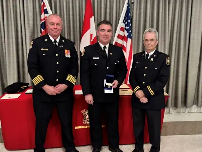 Fire Chief Brian Moore, with Jay Bottan, who received a medal recognizing 20-years of service, and Scott Hayes.