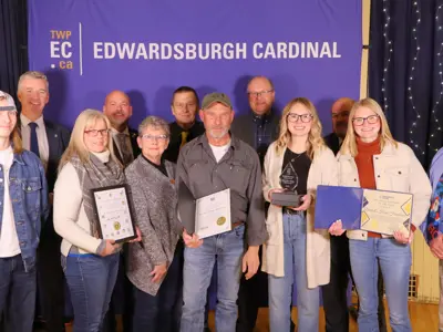 Group of people holding certificates and an award in front of TWPEC backdrop.