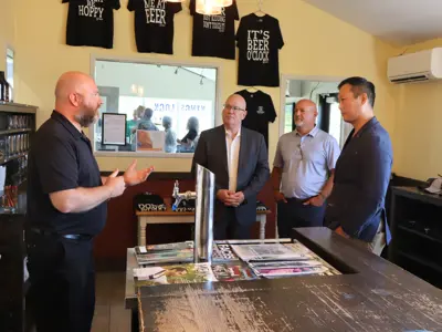 Brewery owner speaking to dignitaries.