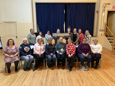 Group of former skating club members gathered behind the time capsule.